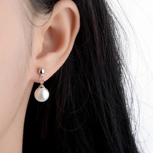 Woman wearing pearl drop stud earrings